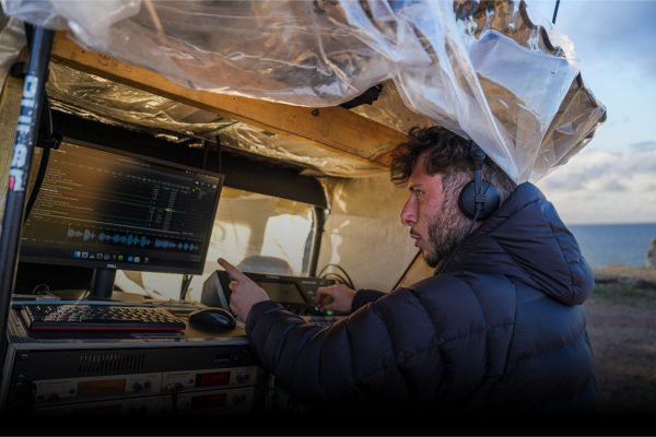 Photo of Dan Balfour, Sound Designer for Stranger Beasts by Wildworks Theatre. Dan is at the sound desk.