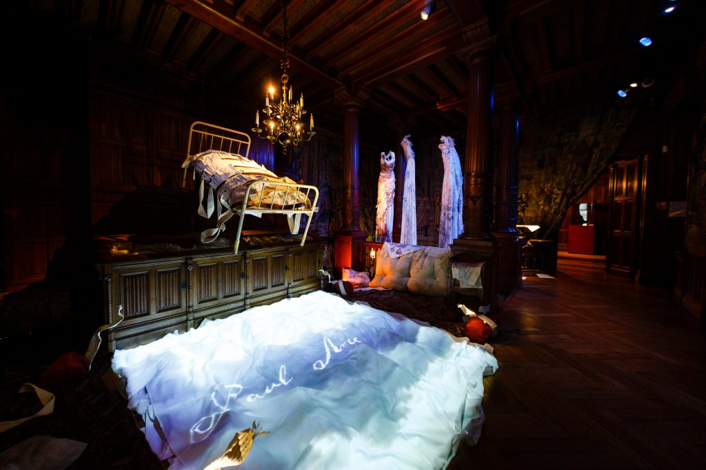 Once and Twice Upon a Castle by Wildworks. A bed is suspended in the air.
