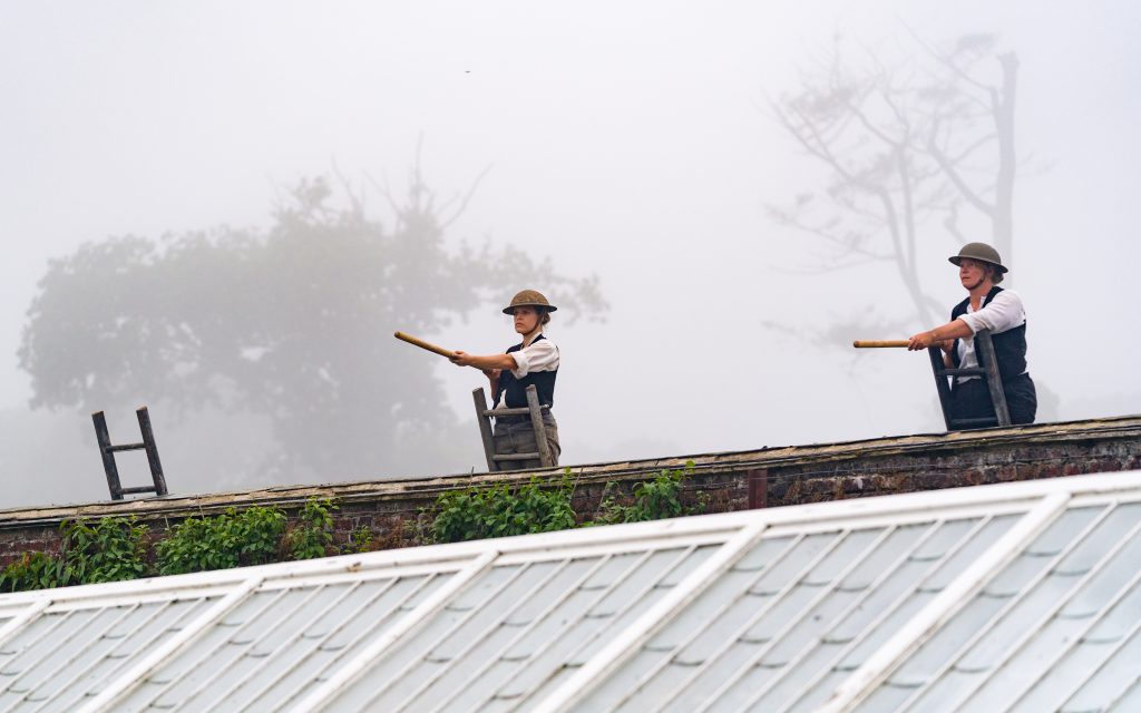 a row of gardeners stood, wearing helmets and brandishing their shovels like weapons, as if ready to go over the top. 100: UnEarth by Wildworks