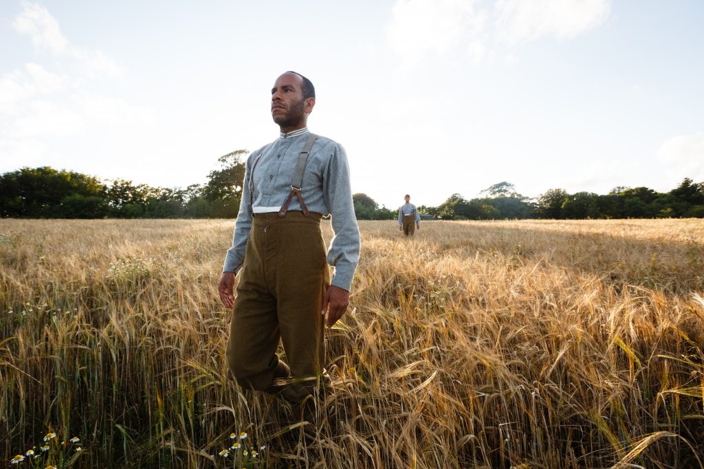 100: The Day Our World Changed by Wildworks. A performer walks through a field of wheat in the departure of the Dead scene. 