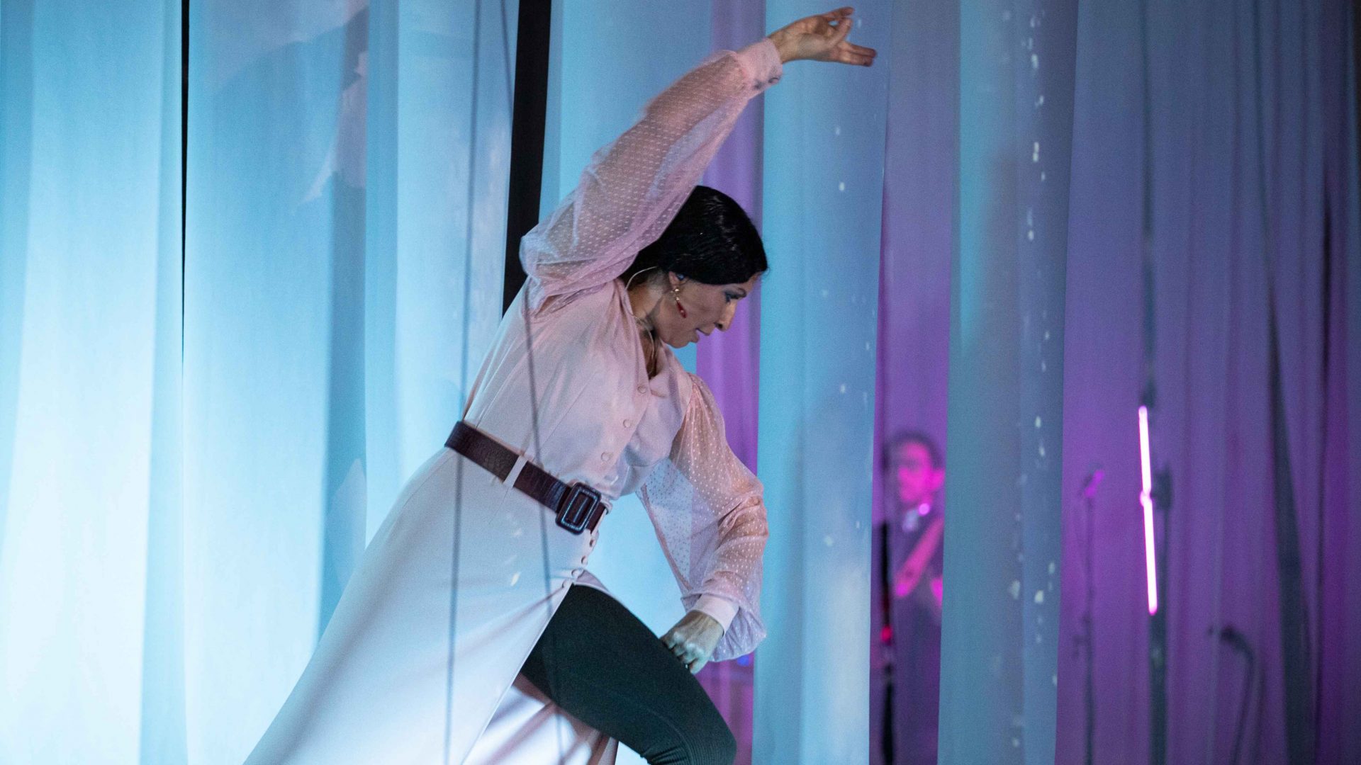 Dancer lit up on stage. Arrow of time set in Malta Aviation Museum in Ta' Qali with Wildworks and Etnika, Magna Żmien, Buena Sombra Films
