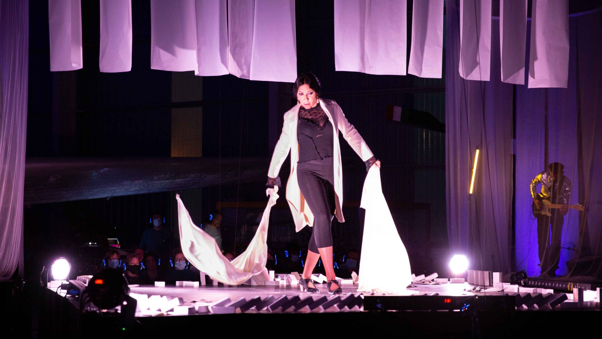 Performer dancing with two pieces of fabric. Arrow of time set in Malta Aviation Museum in Ta' Qali with Wildworks and Etnika, Magna Żmien, Buena Sombra Films